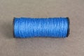 Spool of blue thread on gray background Royalty Free Stock Photo