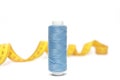 Spool of blue thread for sewing and centimeter on a white background. Royalty Free Stock Photo
