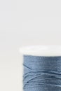 Spool of blue thread with very limited focus on white background. Royalty Free Stock Photo