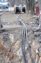 Spool of cabel. Wooden coil of electric cable, optical fibres in the digging trench on the construction site Royalty Free Stock Photo