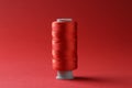 Spool of colorful sewing thread on red background Royalty Free Stock Photo