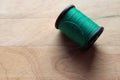 Spool of green thread with copy space isolated on wooden background closeup Royalty Free Stock Photo