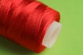Spool of red sewing thread on green background, closeup Royalty Free Stock Photo