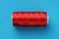 Spool of red sewing thread on light blue background Royalty Free Stock Photo
