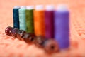 Spool of sewing thread with bobbin on the orange cloth Royalty Free Stock Photo