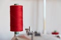 Spool of Thread and Needle, red spool of thread mounted on the sewing machine Royalty Free Stock Photo
