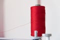 Spool of Thread and Needle, red spool of thread mounted on the sewing machine Royalty Free Stock Photo
