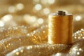 A spool of thread sitting on top of a gold fabric Royalty Free Stock Photo