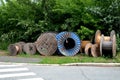 The spool is used for unloading cables, wires and pipes. warehouse of old wooden and metal spools by the road at a construction si Royalty Free Stock Photo