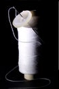 Spool of White Thread with Needle and White Button on Black Background Royalty Free Stock Photo