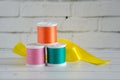 Spools of colored thread, in workplace next to brick wall. Concept: needlework, sewing, handicraft Royalty Free Stock Photo