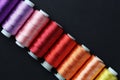 Spools of colorful sewing threads on black background, flat lay Royalty Free Stock Photo
