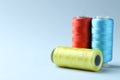 Spools of colorful sewing threads on light background, closeup. Space for text Royalty Free Stock Photo