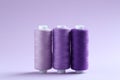 Spools of colorful sewing threads on lilac background Royalty Free Stock Photo