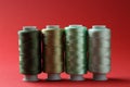 Spools of colorful sewing threads on red background Royalty Free Stock Photo