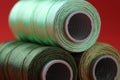 Spools of colorful sewing threads on red background, closeup Royalty Free Stock Photo