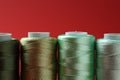 Spools of colorful sewing threads on red background, closeup Royalty Free Stock Photo