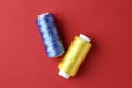 Spools of colorful sewing threads on red background, flat lay Royalty Free Stock Photo
