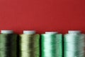 Spools of colorful sewing threads on red background, flat lay. Space for text copy Royalty Free Stock Photo