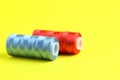 Spools of colorful sewing threads on yellow background, closeup. Space for text Royalty Free Stock Photo