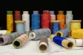 Spools with multi-colored threads on black background, close-up shot Royalty Free Stock Photo