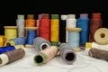 Spools with multi-colored threads on black background, close-up shot Royalty Free Stock Photo