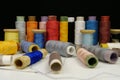 Spools with multi-colored threads on black background, close-up shot Royalty Free Stock Photo