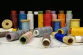Spools with multi-colored threads on black background, close-up shot Royalty Free Stock Photo