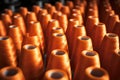Spools of orange thread in a textile factory. Macro shot with shallow depth of field Royalty Free Stock Photo