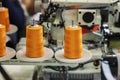 Spools with orange threads on sewing machine. Sewing Equipment, Textile Industry Royalty Free Stock Photo
