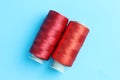 Spools of red sewing threads on light blue background, top view Royalty Free Stock Photo