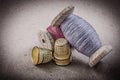 Spools of sewing threads thimbles on vintage background needlewo