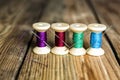 Spools of thread with needles on wooden background. Old sewing a Royalty Free Stock Photo