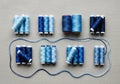 Spools of thread in varying shades of blue are neatly arranged on a light gray textured fabric Royalty Free Stock Photo