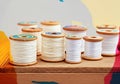 Spools of white thread arranged on a wooden surface, ideal for sewing projects Royalty Free Stock Photo