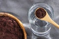Spoon with acai powder to mix with water - Euterpe oleracea
