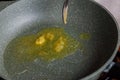 spoon adding butter to vegetable oil on empty preheated skillet Royalty Free Stock Photo