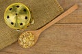 Spoon of aromatic yellow resin gum next to brass incense burner