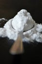 Spoon of baking soda on black background, selective focus Royalty Free Stock Photo