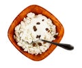 Spoon in bowl with cottage cheese, sour cream and raisin isolated on whitr background. Top view Royalty Free Stock Photo