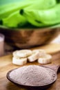 Spoon with banana flour and fruits in the background, point focus. Alternative and homemade flour