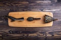 Spoon with black caviar and smoked sturgeon fish on cutting board on wooden background.