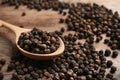 Spoon and black peppercorns on table Royalty Free Stock Photo