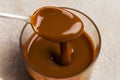 Spoon with caramel in glass jar, close up Royalty Free Stock Photo