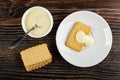 Spoon in bowl with condensed milk, stack of cookies, cookie poured milk in saucer on wooden table. Top view Royalty Free Stock Photo