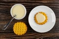 Spoon in bowl with condensed milk, waffle cookies on table, cookie poured condensed milk in saucer. Top view Royalty Free Stock Photo