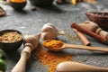 Spoon and bowl with different dry spices on grunge background Royalty Free Stock Photo