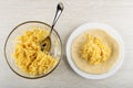 Spoon in bowl with mix of grated cheese and egg, flatbread with cheese in plate on wooden table. Top view Royalty Free Stock Photo