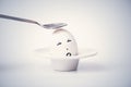 Spoon breaks sad egg on a stand in the form of human head . Royalty Free Stock Photo