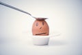 Spoon breaks sad egg on a stand in the form of human head . Royalty Free Stock Photo